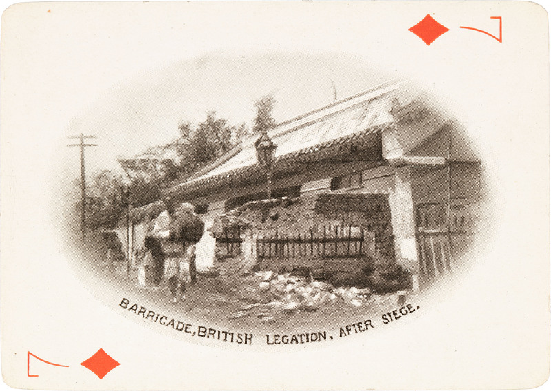The 7 of diamonds with a picture of makeshift barricade outside a building 