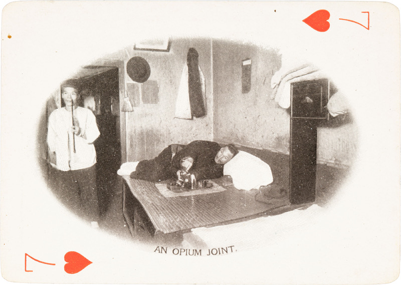 The 7 of hearts with a picture of a man laying on a mat with another man standing next to him
