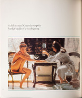 Photo of two women sitting at a table holding hands. One woman is naked and looking at the viewer, the other is in a robe holding a drink and looking down.